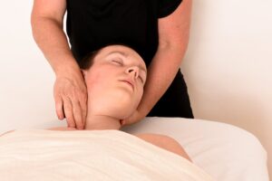 Body SDS behandling i Næstved hos AkuZoMa – Marianne Lisborg arbejder med pulserende massage på nakke og skuldre.